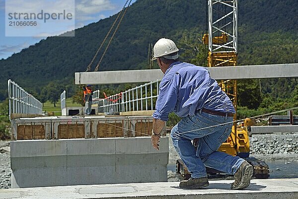 Bauarbeiter errichten eine Betonbrücke über einen kleinen Fluss in Westland  Neuseeland  Ozeanien