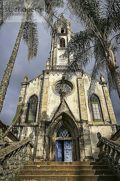 Frontansicht einer Kirche mit Palmen im Sonnenlicht  Wallfahrtskirche Caraca  Minas Gerais  Brasilien  Südamerika