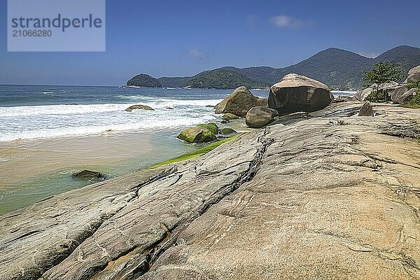 Blick entlang der schönen Küste mit Felsplatten und Bergen im Hintergrund  Picinguaba  Brasilien  Südamerika