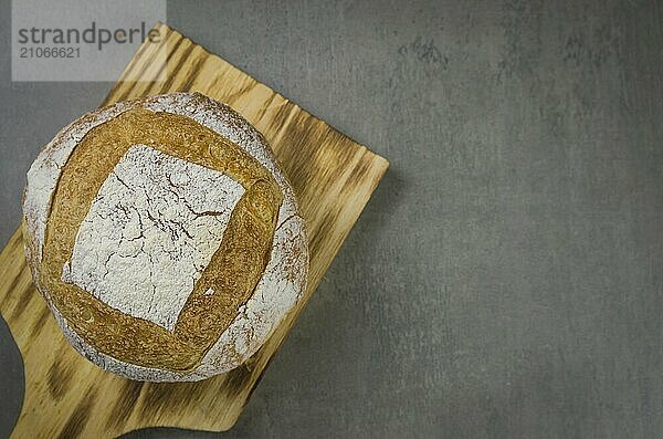 Schönes Sauerteigbrot auf grauem Hintergrund mit getrockneter Weizenblüte