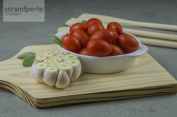 Holzbrett mit Kirschtomaten auf grauem Hintergrund. kulinarischen Hintergrund