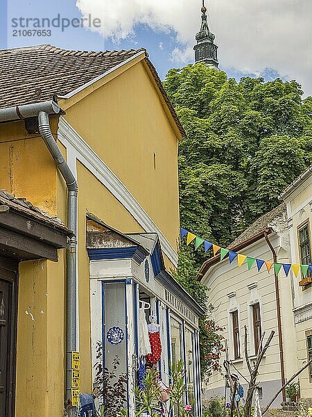 Dorfstraße mit gelbem Gebäude  bunten Girlanden und fröhlicher Atmosphäre bei Sonnenschein  esztergom  donau  ungarn