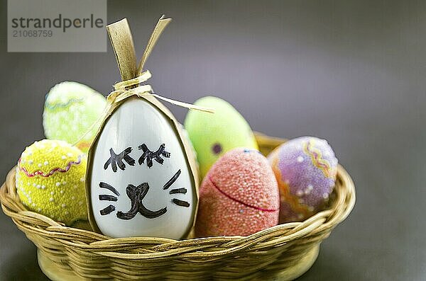 Glückliche Ostern Hase Ei und Eier gefärbte Eier in einem Korb vor einem trendigen schwarzen Hintergrund. Minimal Ostern Konzept. Osterkarte mit Kopie Raum für Text