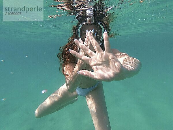 Junge Studentin schwimmt unter Wasser und hat Spaß im Sommer im schönen blauen Meer