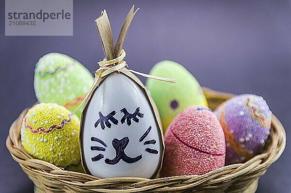 Glückliche Ostern Hase Ei und Eier gefärbte Eier in einem Korb vor einem trendigen schwarzen Hintergrund. Minimal Ostern Konzept. Osterkarte mit Kopie Raum für Text