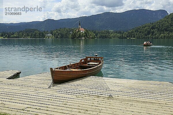 Bleder See mit traditionellem Boot. Schöner Bergsee im Sommer mit kleiner Kirche auf einer Insel mit Schloss auf einer Klippe und Alpen im Hintergrund