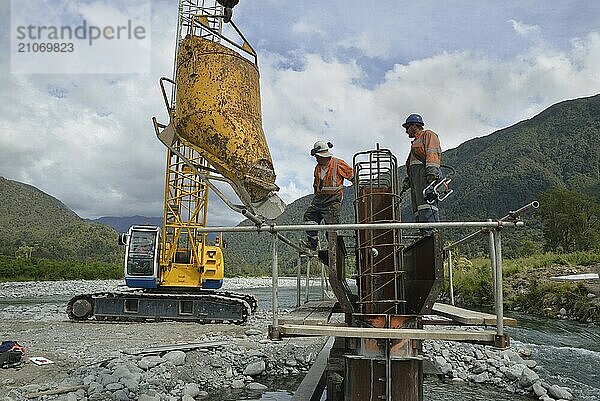 Bauarbeiter errichten eine Betonbrücke über einen kleinen Fluss in Westland  Neuseeland  Ozeanien