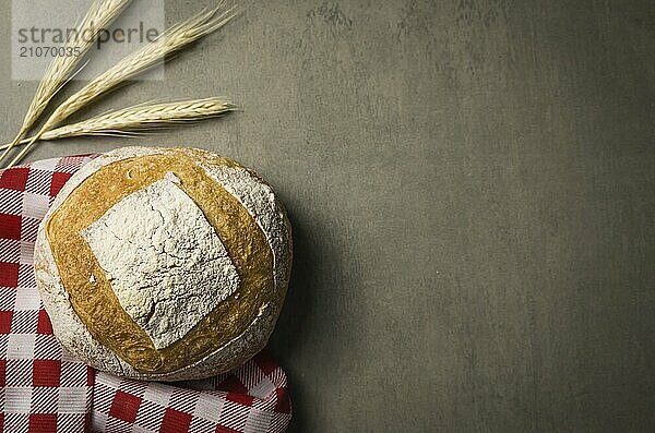 Schönes Sauerteigbrot auf grauem Hintergrund mit getrockneter Weizenblüte