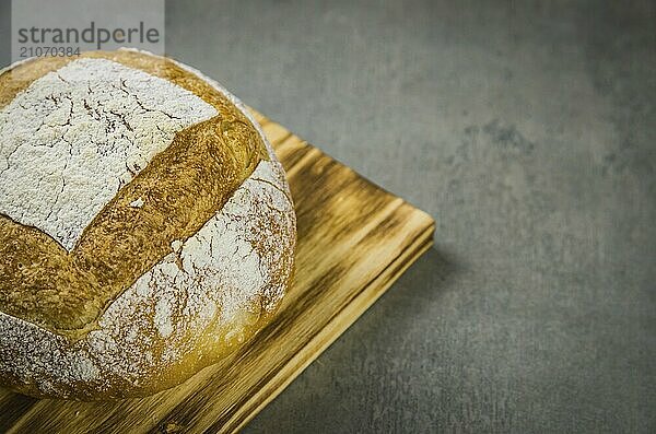 Schönes Sauerteigbrot auf grauem Hintergrund mit getrockneter Weizenblüte