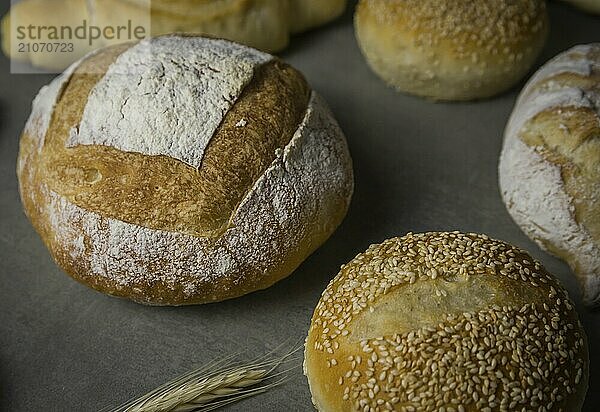 Schönes Sauerteigbrot auf grauem Hintergrund mit getrockneter Weizenblüte