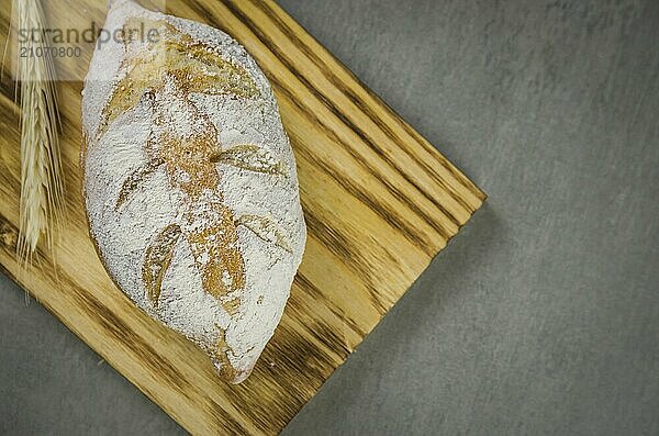 Schönes Sauerteigbrot auf grauem Hintergrund mit getrockneter Weizenblüte