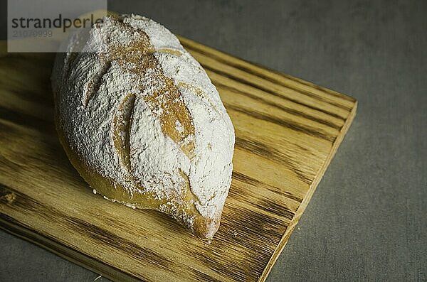 Schönes Sauerteigbrot auf grauem Hintergrund mit getrockneter Weizenblüte