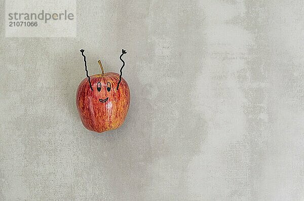 Großes Konzept der gesunden Ernährung  Apfel mit glücklichem Gesicht und Arme nach oben in grauem Hintergrund