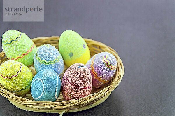 Ostern farbige Eier in einem Korb vor einem trendigen schwarzen Hintergrund. Minimale Ostern Konzept. Osterkarte mit Kopierraum für Text