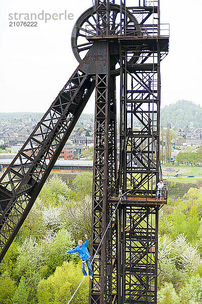 Highliner balancing on tightrope on mine shaft tower  Charleroi  Wallonia  Belgium