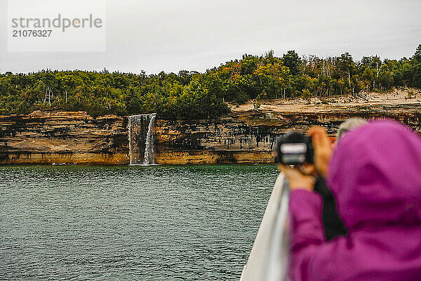 Tourists photographing waterfall at Pictured Rocks NationalÂ Lakeshore Â Munising  Michigan  USA