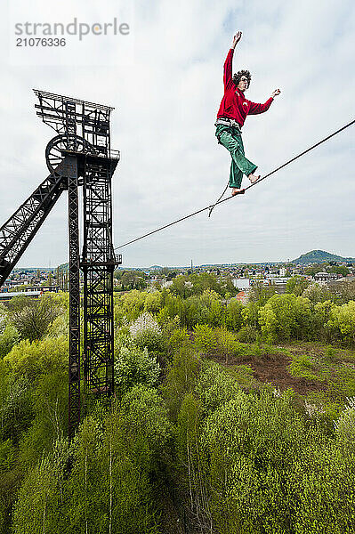 Highliner balancing on tightrope on mine shaft tower  Charleroi  Wallonia  Belgium