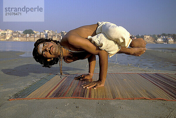 A Yogi Priest practices by Yoga near the Ganges River  Varanasi  Uttar Pradesh  India.