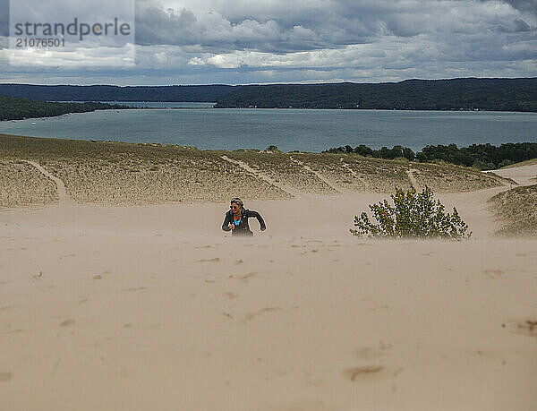 Female hiker running up sand dune in Sleeping Bear Dunes NationalÂ Lakeshore  Empire  Michigan  USA