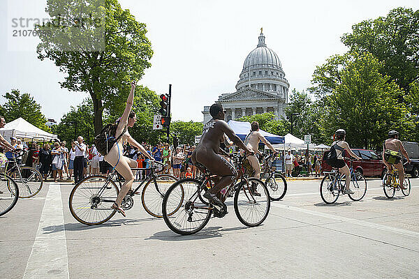 Large number of naked cyclists riding by state capitol to protest dependence on fossil fuels  Madison  Wisconsin  USA