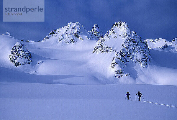 Two skiers ski tour and explore the Lyngen Alps of Norway.