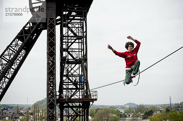 Highliner balancing on tightrope on mine shaft tower  Charleroi  Wallonia  Belgium