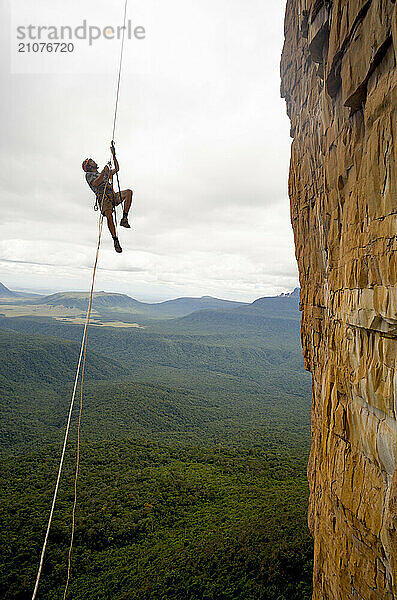 Man climbing steep cliff