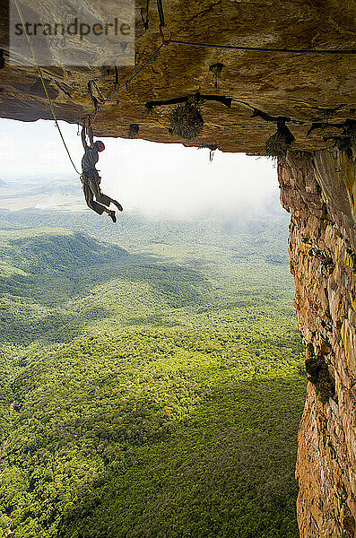 Man climbing rock ceiling at Maria Rosa