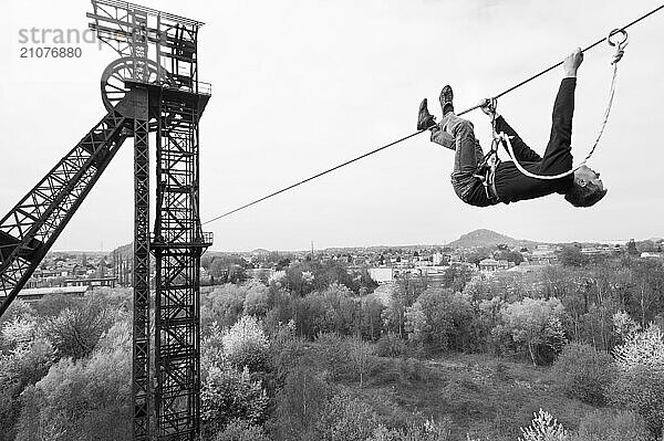 Highliner hanging from tightrope on mine shaft tower  Charleroi  Wallonia  Belgium