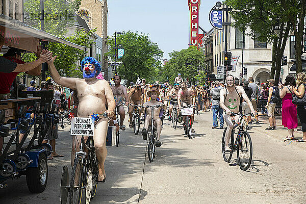 Large number of naked cyclists riding along street to protest dependence on fossil fuels  Madison  Wisconsin  USA