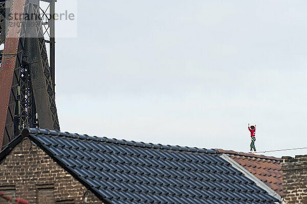 Highliner balancing on tightrope on mine shaft tower  Charleroi  Wallonia  Belgium