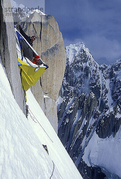 Two men look out from their tent on the wall of K7  Karakoram Mountains  Pakistan.