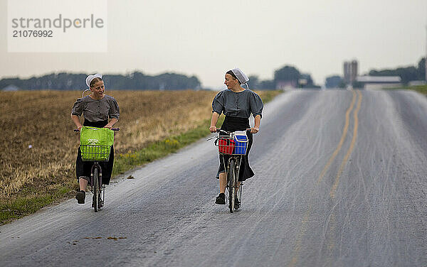 Two Amish women riding bicycles  Intercourse  Lancaster County  Pennsylvania  USA