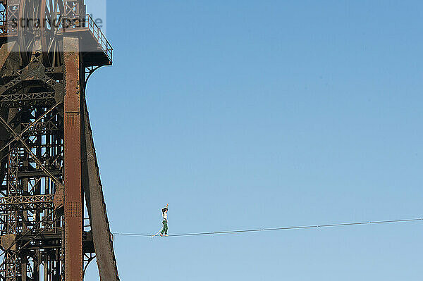 Highliner balancing on tightrope on mine shaft tower  Charleroi  Wallonia  Belgium