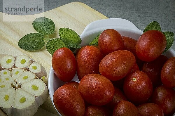 Holzbrett mit Kirschtomaten auf grauem Hintergrund. kulinarischen Hintergrund