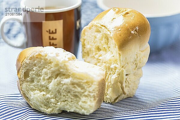 Mini Butter Brioche mit Kaffeebecher auf hellblauem Hintergrund