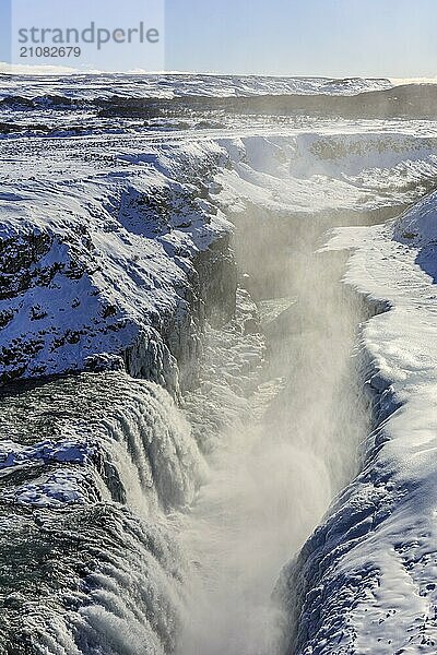 Großer Wasserfall in einer Schlucht im Schnee  Winter  sonnig  Gegenlicht  Gischt  Gullfoss  Golden Circle  Südwestisland  Island  Europa