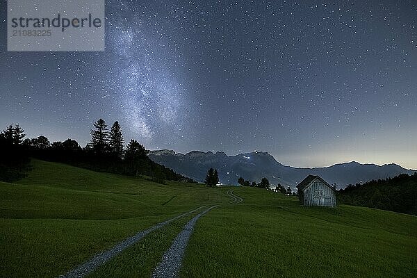 Eine klare Nacht mit Blick auf die Milchstraße über einer Wiese und einem abgelegenen Hütte mit Bergsicht  Fähnerenspitz  Brülisau  Appenzell Innerrhoden  Schweiz  Europa