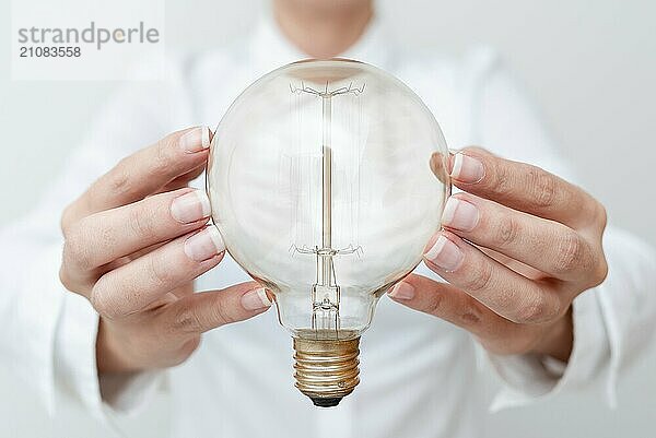 Lady Holding Lampe mit formalen Outfit präsentiert neue Ideen für Projekt  Business Frau zeigt Glühbirne mit zwei Händen ausstellen neue Technologien  Glühbirne präsentiert eine andere Openion