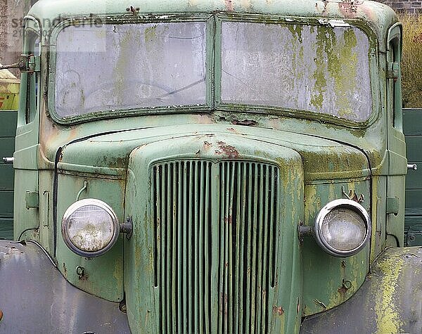 Vorderansicht eines alten verlassenen rostigen grünen Oldtimer LKW