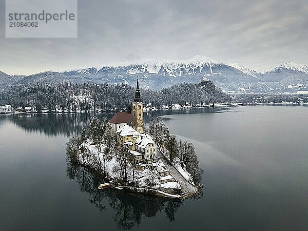 Luftaufnahme des Bleder Sees an einem ruhigen Wintermorgen mit Schnee