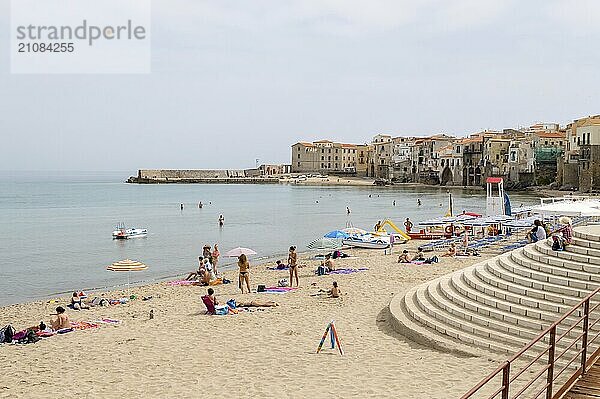 View of the beach of Cefalu with the old city in the background in the north of Sicily in Italy