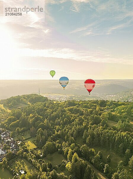 Heißluftballons fliegen über bewaldete Hügel in einer Landschaft bei Sonnenuntergang  Calw  Schwarzwald  Deutschland  Europa