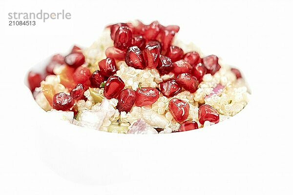 Quinoa Salat mit Granatapfelkernen  Radiccio  Gurke und Oliven auf weißem Hintergrund