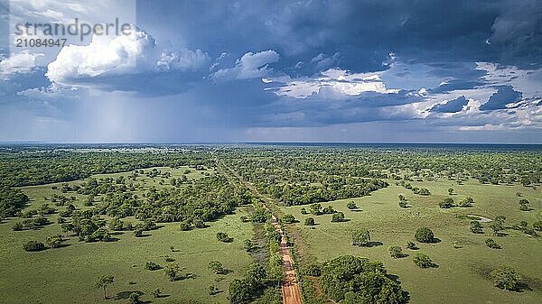 Luftaufnahme der unbefestigten Transpantaneira Straße mit dramatischem Himmel und Regen  die die typische Landschaft im nördlichen Pantanal Feuchtgebiet  Mato Großo  Brasilien  durchquert  Südamerika