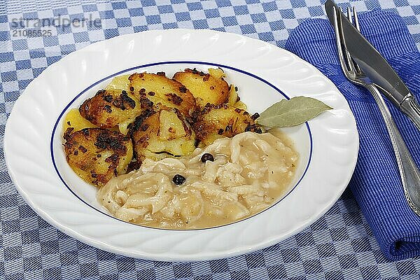 Schwäbische Küche  Saure Kutteln mit Röstkartoffeln  Kartoffelrädchen angebraten  Fleischgericht  Innereien  deftig  salzig  typisch Schwäbisch  Hausmannskost  Traditionsküche  Lorbeerblatt  Wacholder  Suppenteller  Foodfotografie  Studio  Deutschland  Europa