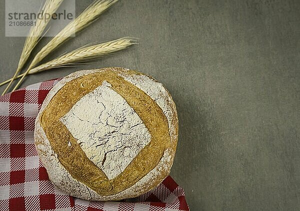 Schönes Sauerteigbrot auf grauem Hintergrund mit getrockneter Weizenblüte