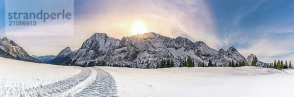 Alpenpanorama mit den Bergen der österreichischen Alpen  von der Gemeinde Ehrwald  den grünen Nadelbäumen und einer dicken Schneedecke auf den Weiden. Eine prächtige Wintersonne überwältigt die ganze Szene