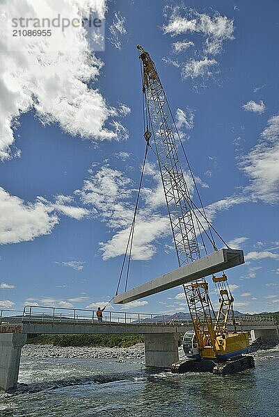 Builders construct a concrete bridge over a small river in Westland  New Zealand  Oceania