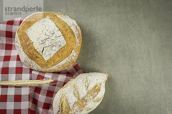 Schönes Sauerteigbrot auf grauem Hintergrund mit getrockneter Weizenblüte